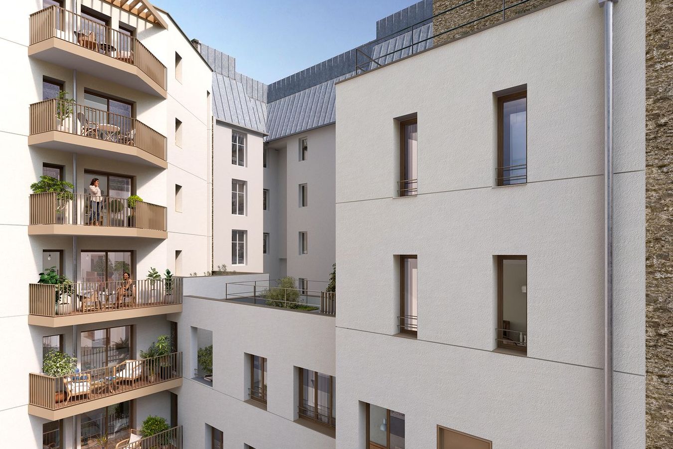 Residential courtyard with white façades, stacked balconies and a retained stone wall